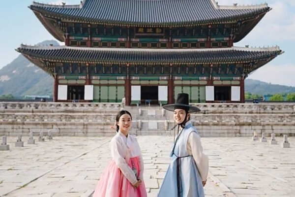 A man and woman dressed in beautiful hanbok in front of Gyeongbokgung Palace
