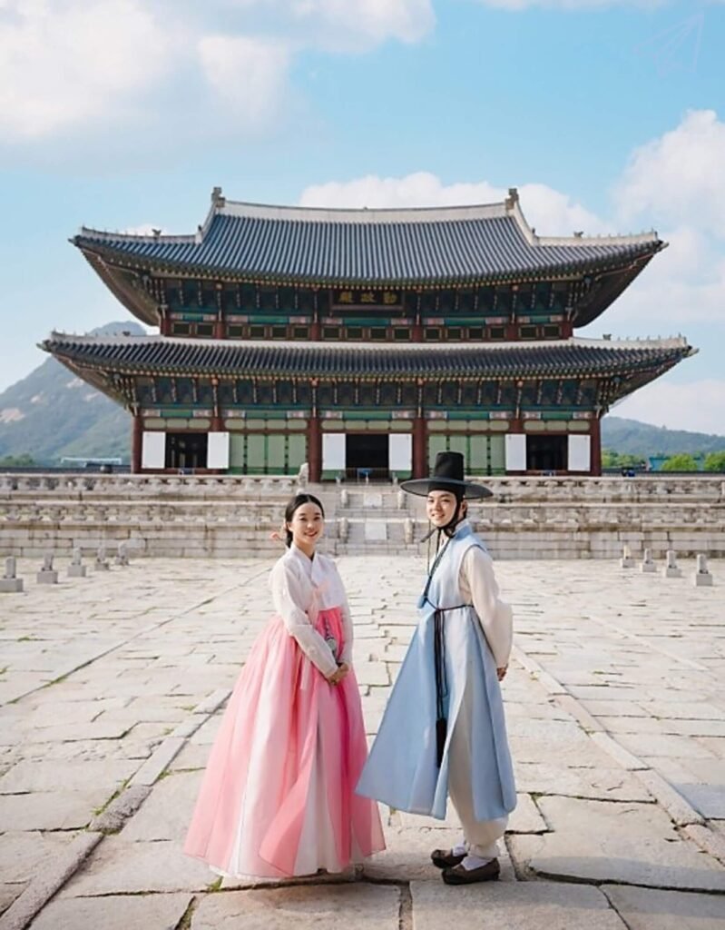 A man and woman dressed in beautiful hanbok in front of Gyeongbokgung Palace