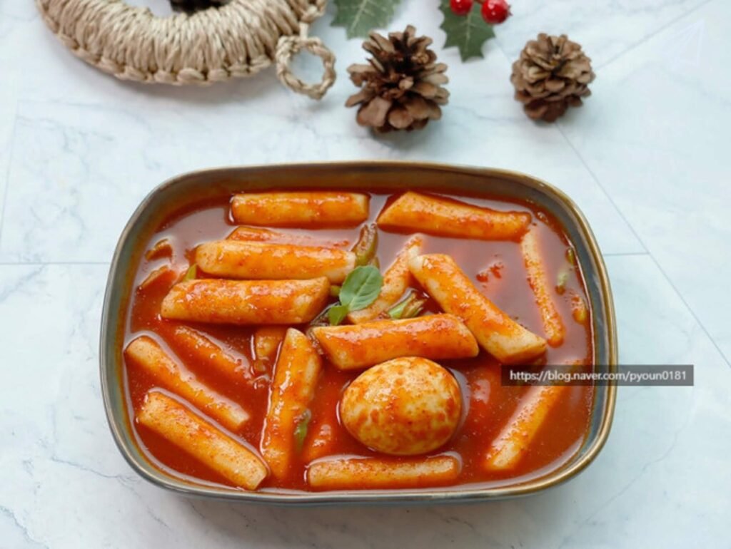 Red cooked tteokbokki and egg in a bowl